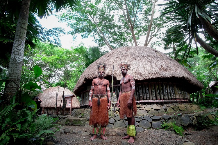 Two men from a local tribe standing in front of a hut in Bali