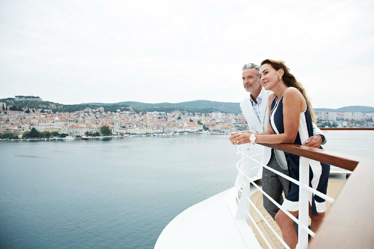 Couple stood together on a balcony aboard Seabourn