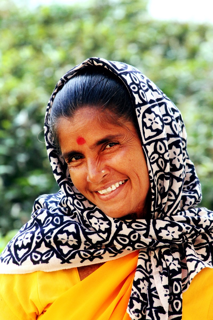 An Indian woman wearing a bright sari and red Bindi smiling into the camera