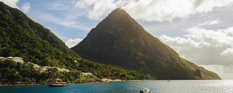 A lush mountain rising up out of the bright blue sea in St Lucia