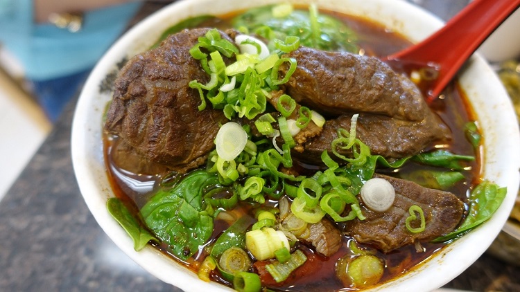 Lanzhou beef noodle soup topped with spring onions