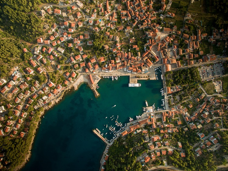A panoramic, aerial shot of Jelsa in Croatia and the surrounding bright blue sea