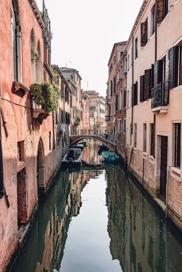 A thin canal between two buildings in Venice