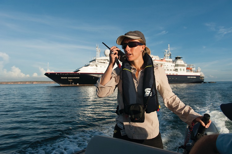 A Silversea expedition cruise guide talking into a walkie-talkie in a Zodiac