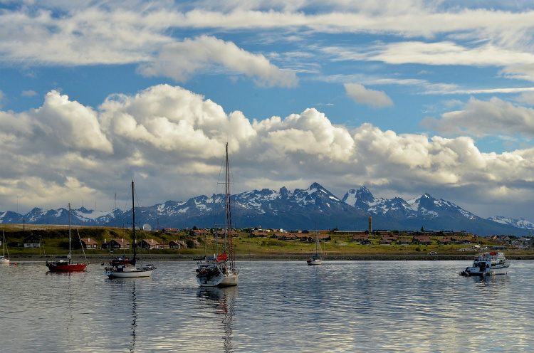 Fishing boats in a harbour in Ushuaia with mountains in the background