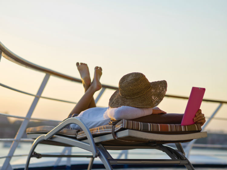 Woman reading tablet on cruise deck